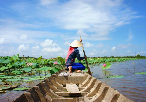 בן אדם על קצה הסירה בנהר בויאטנם עם פרחים עליו
