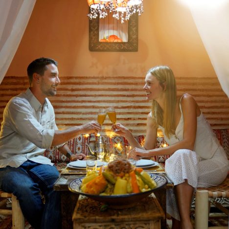 זוג בארוחה עושה לחיים עם כוסות שמפנייה במרוקו