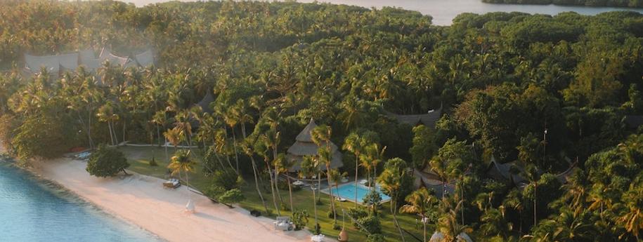 מלון נאי פאלנד עם גגות קש בצורת משולש בריכת שחיה ויער דקלים מסביב מול חוף הים
