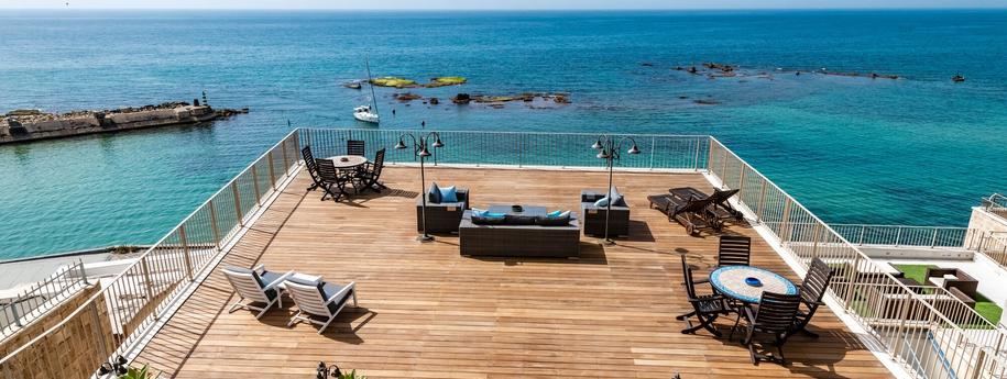 מרפסת מלון ענקית מול הים עם מקומות ישיבה שונים