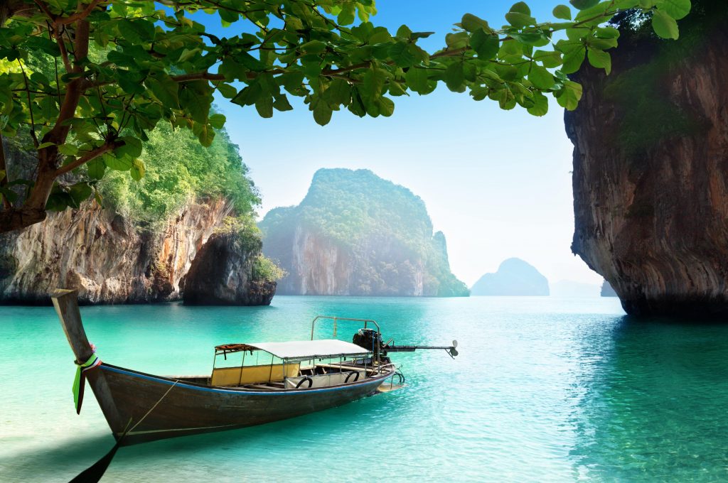 קופיפי תאילנד - נוף של סלעים ענקיות וסירה על החוף