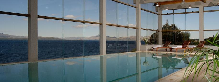 בריכת המלון בתוך המבנה עם חלונות זכוכית שמשקיפים לים