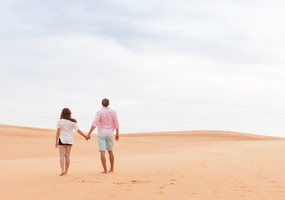 זוג במדבר מחזיק יד ביד