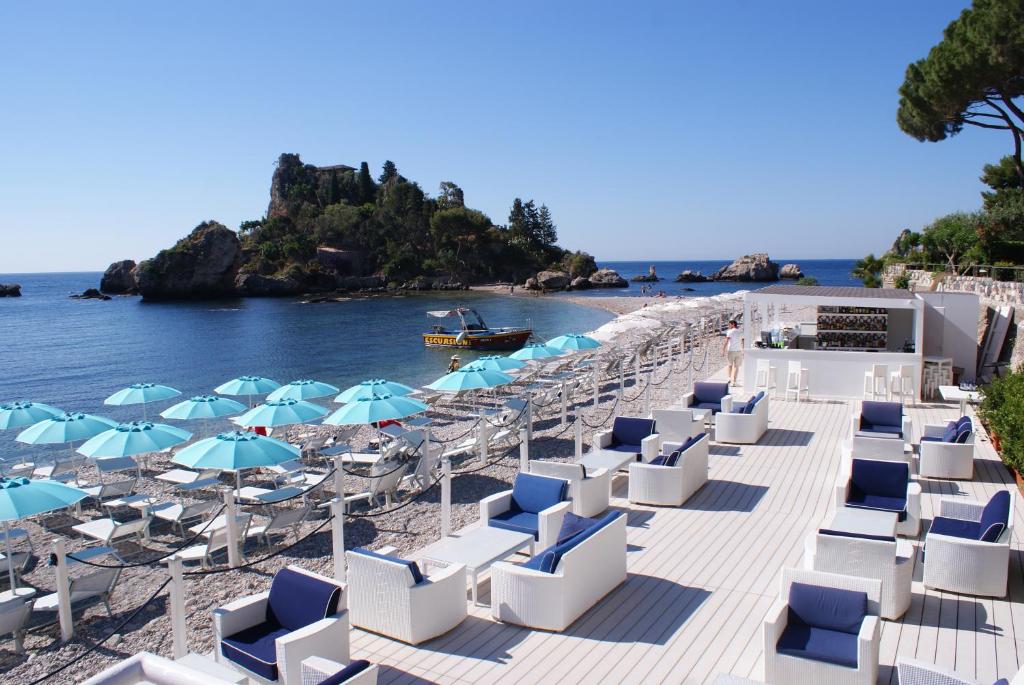 חוף הים של המלון עם מיטות שיזוף ודקך עם מקומות ישיבה