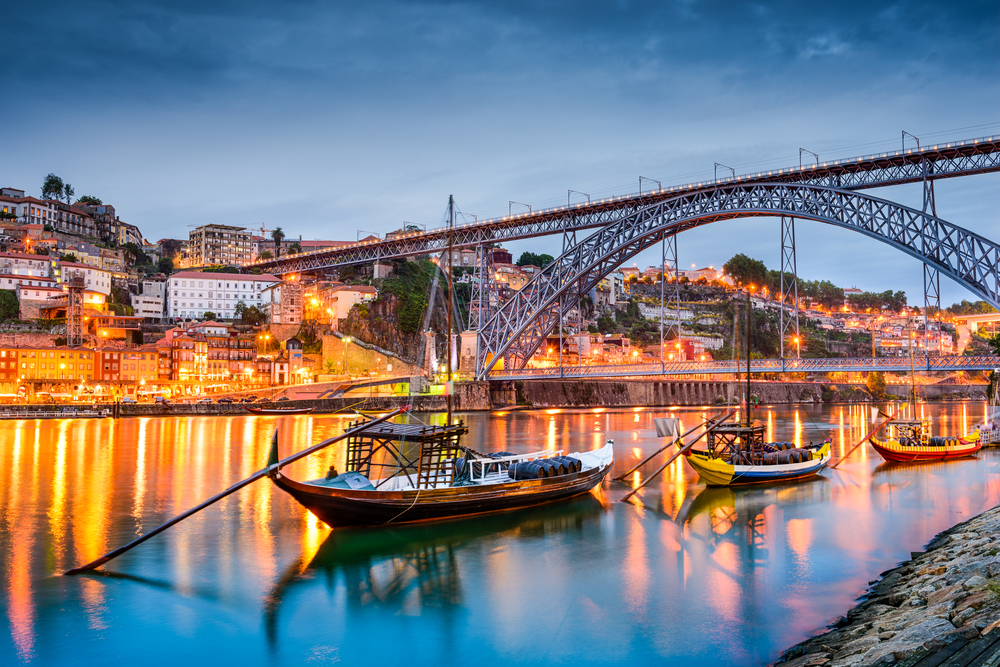 נהר בפורטו בערב עם 3 סירות וגשר מעליו