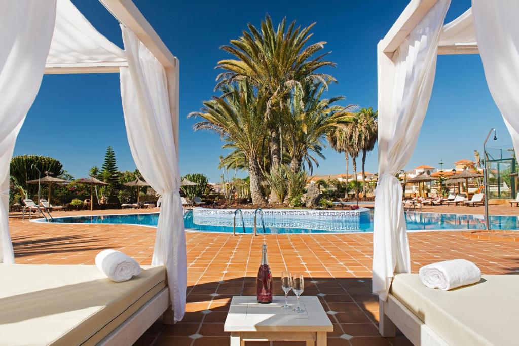 מלון אלבה פאלאס גולף אנד ויטאל - בריכת המלון עם מיטות שיזוף שולחן עם שמפניה ו2 כוסות 